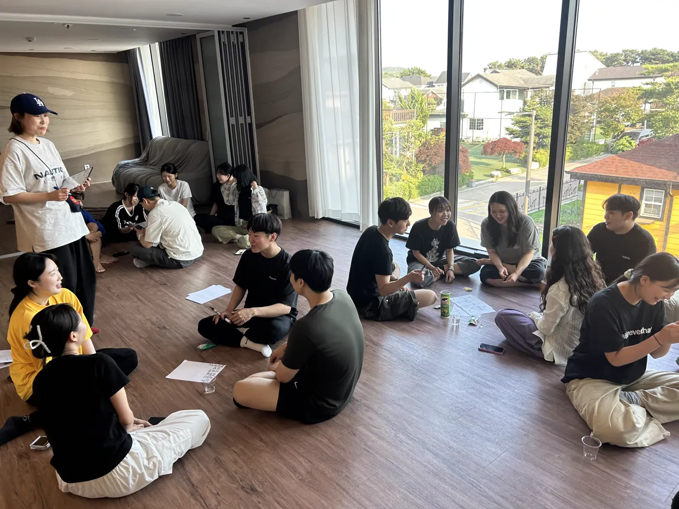 워크숍에서 둘러앉아 이야기 나누며 웃는 팀원들