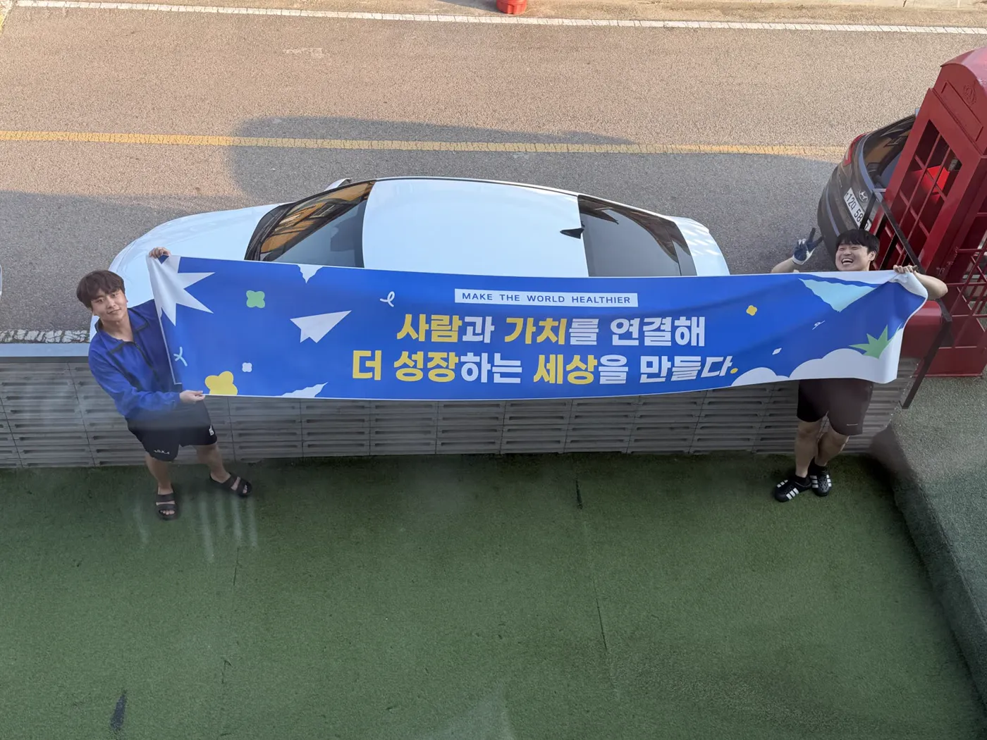 워크숍 현수막을 양쪽에서 펼쳐 든 팀원들