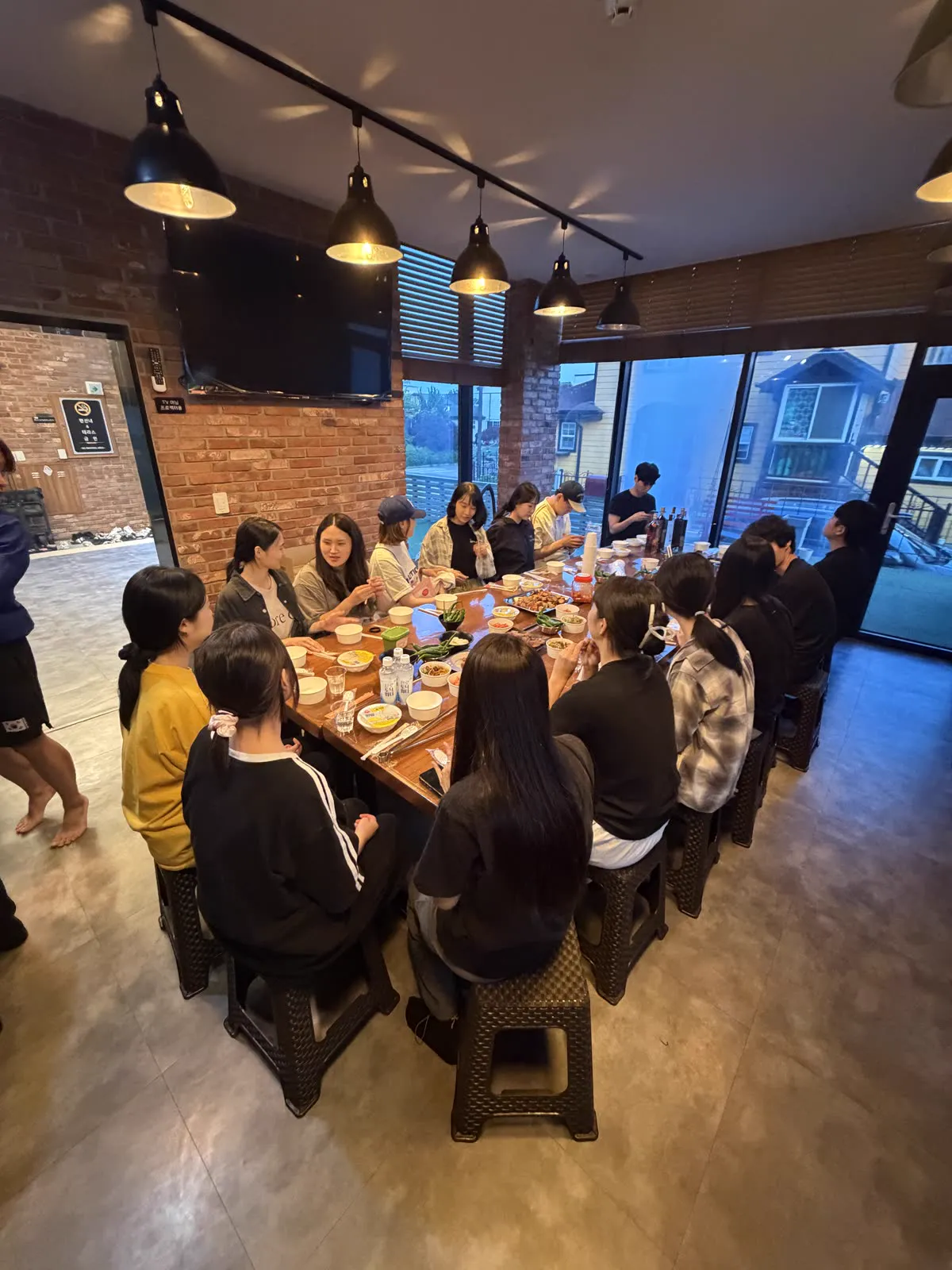 워크숍 저녁, 긴 테이블에 다 같이 둘러앉아 저녁을 먹는 팀원들